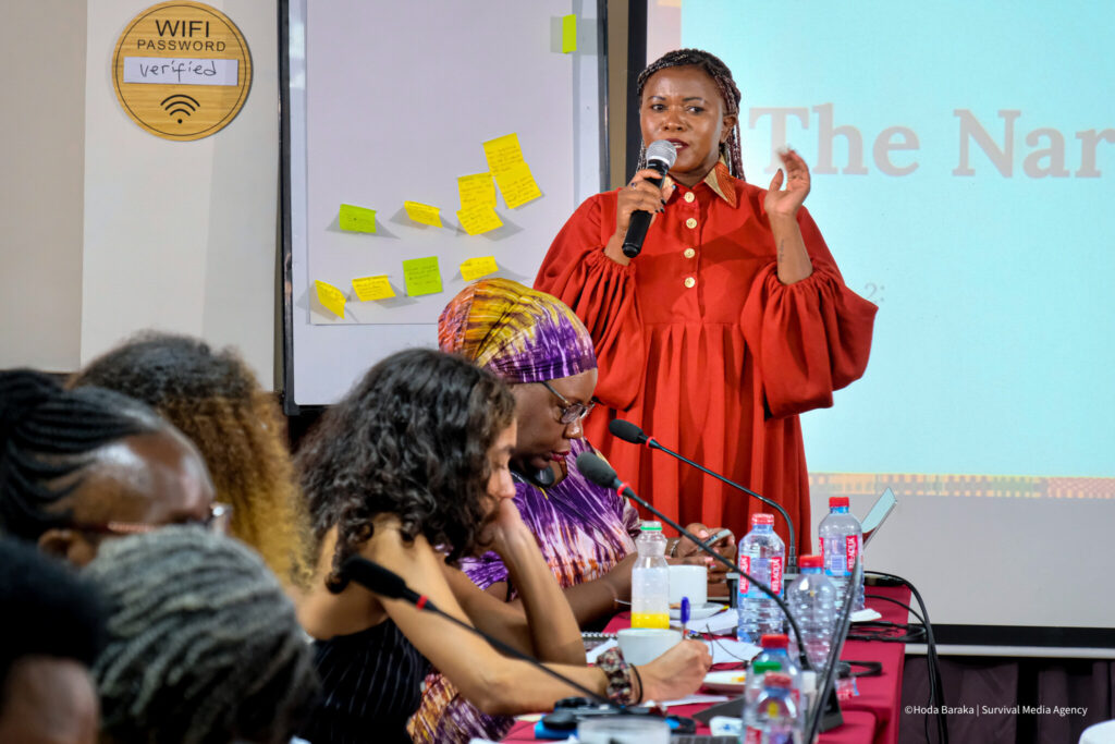 A woman in a red dress speaking into a microphone.