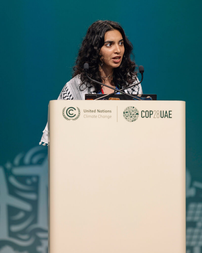 A speaker stands at a podium displaying the United Nations Climate Change logo at the COP28 UAE conference.